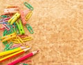 Colorful pencil and paperclips on old paper background Royalty Free Stock Photo