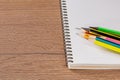 Colorful pencils and blank notepad on organized office workspace