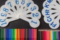 Colorful pencils and cards of numerals and letters of alphabet on the chalkboard Royalty Free Stock Photo