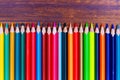 Colorful pencils lying on wooden board