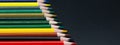 Colorful pencils made of wood slanted together with dark background and copy space for free text in panorama format Royalty Free Stock Photo