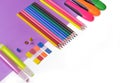 pencils and neon pens on mauve paper and white Royalty Free Stock Photo