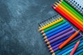 Colorful pencils and notebook on a blackboard Royalty Free Stock Photo