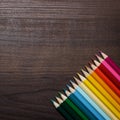 Colorful pencils over brown table background Royalty Free Stock Photo