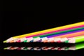 Colorful pencils in a row on black background Royalty Free Stock Photo