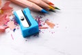 Colorful pencils, sharpener and shavings on white wooden background, closeup Royalty Free Stock Photo