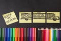 Colorful pencils, titles Back to school and school bus drawn on the pieces of paper on the chalkboard Royalty Free Stock Photo