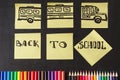 Colorful pencils, titles Back to school and school bus drawn on the pieces of paper on the chalkboard Royalty Free Stock Photo