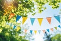 Colorful pennant decoration in green foliage on blue sky Royalty Free Stock Photo