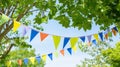 colorful pennant string decoration in green tree foliage on blue sky, summer party. Generative Ai Royalty Free Stock Photo