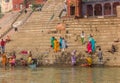 Colorful people at the stairs to the Ganges river in Varanasi