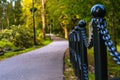 Colorful Photo of the Road in a Park, Between Woods - Closeup view of the Chain Fence with Blurred Background with Space for Text