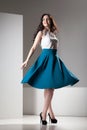 Colorful photo of a woman in white top and dark blue skirt