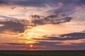 A colorful, picturesque sky above the field during the sunset_ Royalty Free Stock Photo