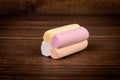 Colorful piece of marshmallow on a brown textured wooden background