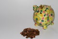 A colorful piggy bank with a money heap of cent coins isolated on a white underground and background Royalty Free Stock Photo