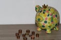 A colorful piggy bank with steepled cent coins on a wood underground Royalty Free Stock Photo