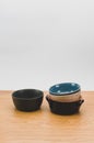 colorful piled up empty stoneware bowls on a wooden tabletop with copy space