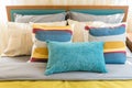 Colorful pillows on wooden bed in modern bedroom Royalty Free Stock Photo