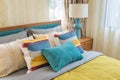 Colorful pillows on wooden bed in modern bedroom design Royalty Free Stock Photo