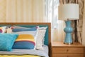 Colorful pillows on wooden bed in modern bedroom Royalty Free Stock Photo