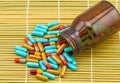 Colorful pills and black bottle tablets on brown bamboo weave