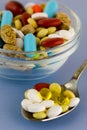 Colorful pills in bowl and spoon Royalty Free Stock Photo