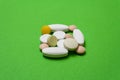 Colorful pills and capsules on a green background Royalty Free Stock Photo