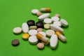 Colorful pills and capsules on a green background Royalty Free Stock Photo