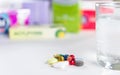 Colorful pills and glass of water, on white background. Royalty Free Stock Photo