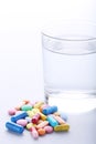 Colorful pills with glass of water Royalty Free Stock Photo