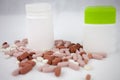 Colorful pills laying on the white background with empty bottles