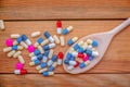 Colorful pills and medication in a wooden cooking spoon, on wood planks background, health medication concept Royalty Free Stock Photo