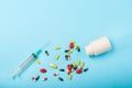 Colorful Pills, Medicine bottle and disposable syringe closeup on blue background. Health pharmacy pharmacology concept with Copy Royalty Free Stock Photo