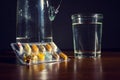 Colorful pills medicine capsule with glass of water on table Royalty Free Stock Photo