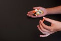 Colorful pills and medicines in the handson black background.. Place for an inscription.