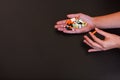 Colorful pills and medicines in the handson black background. Place for an inscription.