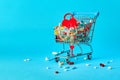 Colorful pills with red heart in shopping cart on blue background. concept: trade in medicines, pharmacies Royalty Free Stock Photo