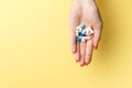 Colorful pills and tablets in the woman hand on yellow background. Top view. Flat lay. Copy space Royalty Free Stock Photo