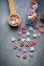 Colorful Pink Red White Sugar Sprinkles Candies Spilled from Small Wood Spoon and Glass Bottle on Grey Background. Valentines Royalty Free Stock Photo