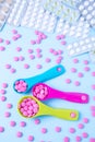 Colorful pink tablets in colored plastic round spoons. Blisters of pills in the background. Concept of medicine Royalty Free Stock Photo