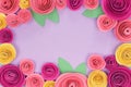 Colorful pink and yellow rose flat lay background with crafted paper flowers around the endges and empty violet copy space Royalty Free Stock Photo