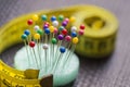 Colorful pins and measuring tape on worktable. Garment sewing