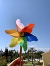 Colorful pinwheel against blue sky in female hand Royalty Free Stock Photo