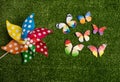 Colorful pinwheel and little colorful butterflies on green grass background Royalty Free Stock Photo