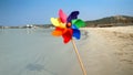 Colorful pinwheel spinning in the wind on a sandy beach, evoking the concepts of travel, summer holiday, vacation, beach tourism, Royalty Free Stock Photo