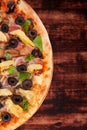 Colorful pizza on dark wooden background.
