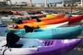 Colorful plactic kayaks or canoe on the beach sand for tourist rent. Surfing boards on stand during summer season Royalty Free Stock Photo
