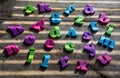 Colorful plastic alphabet letters on a wooden background.