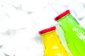 Colorful plastic bottles with ice cubes white desk background to Royalty Free Stock Photo